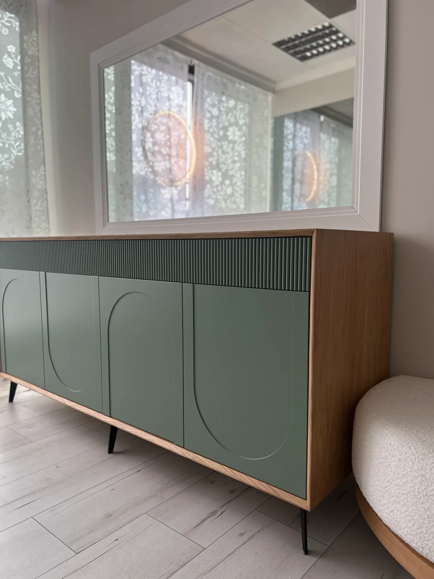 Niska szafka sideboard na wymiar z czterema szałwiowymi frontami z wyfrezowanymi łukami, górnym pasem poziomych lameli i dębową ramą, na czarnych metalowych nóżkach.